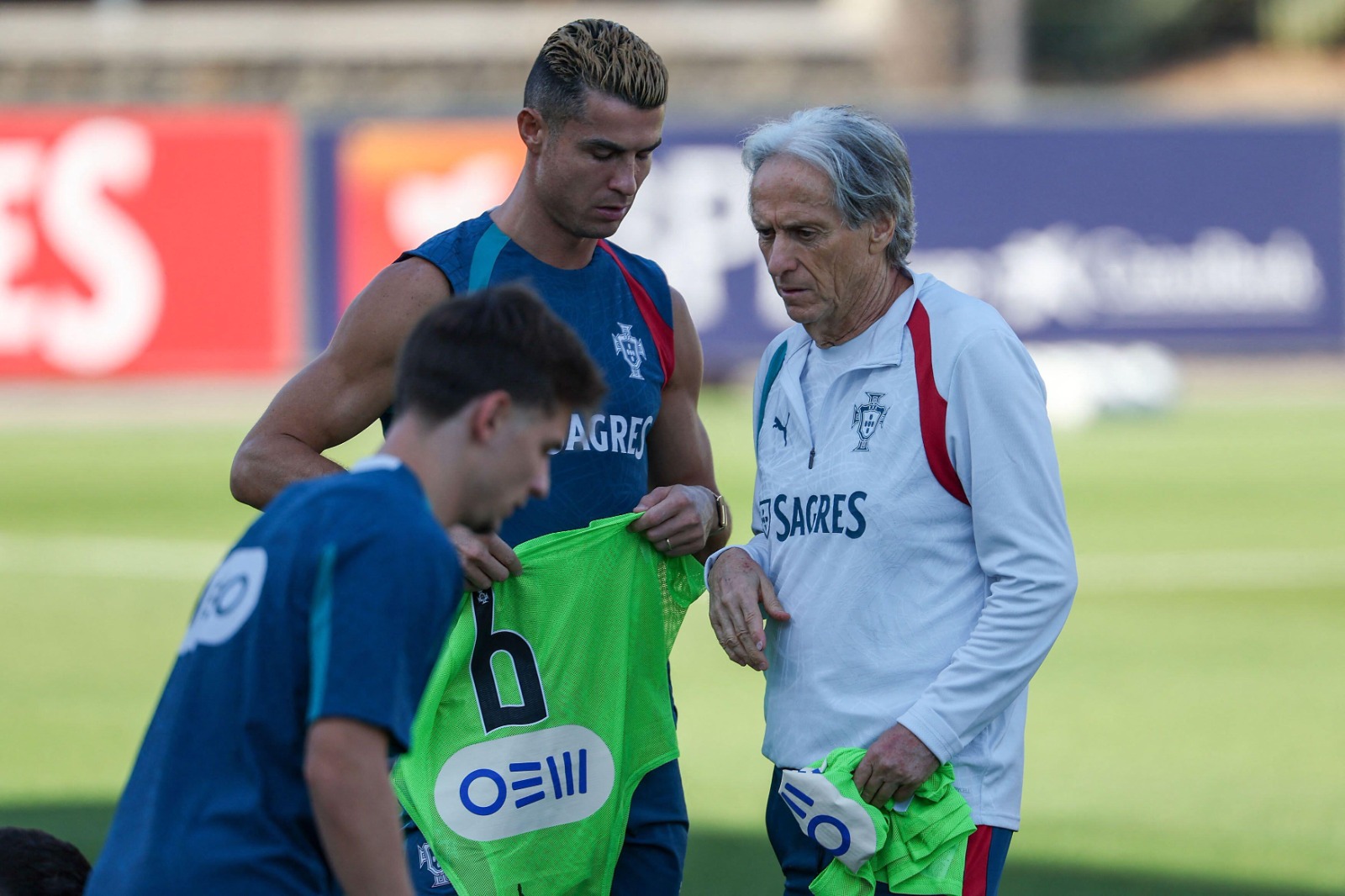 Cristiano Ronaldo and Jorge Jesus holding green bibs during Portugal training.